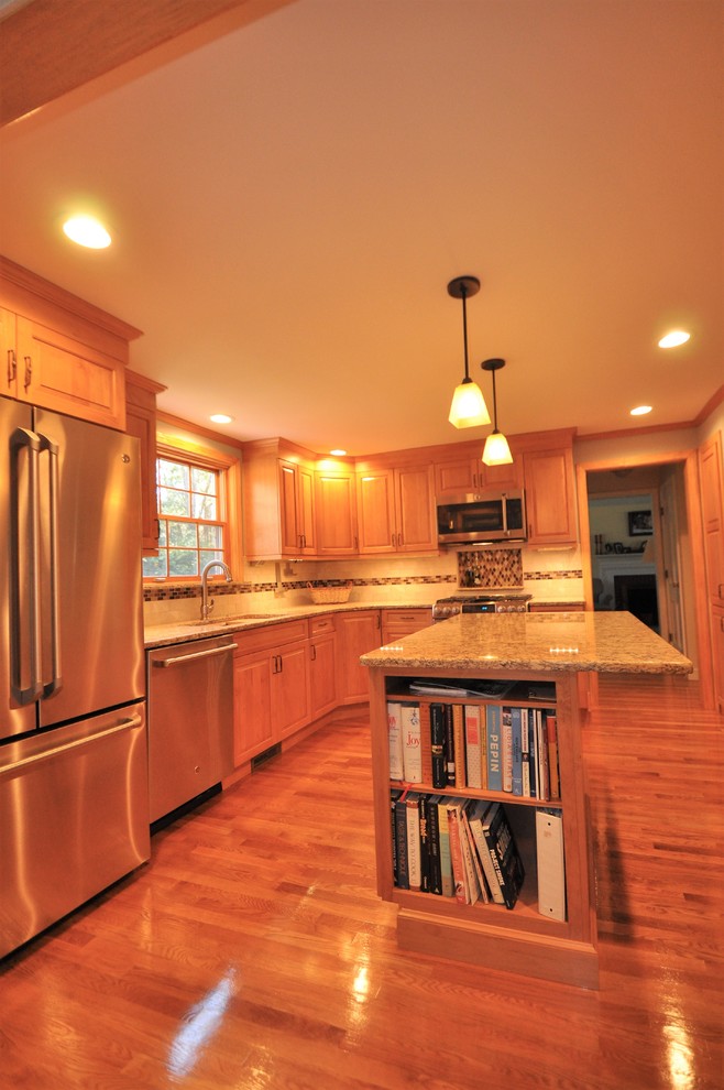 Exempel på ett mellanstort klassiskt kök, med en undermonterad diskho, luckor med upphöjd panel, skåp i ljust trä, bänkskiva i kvarts, beige stänkskydd, stänkskydd i keramik, rostfria vitvaror, ljust trägolv, en köksö och rött golv