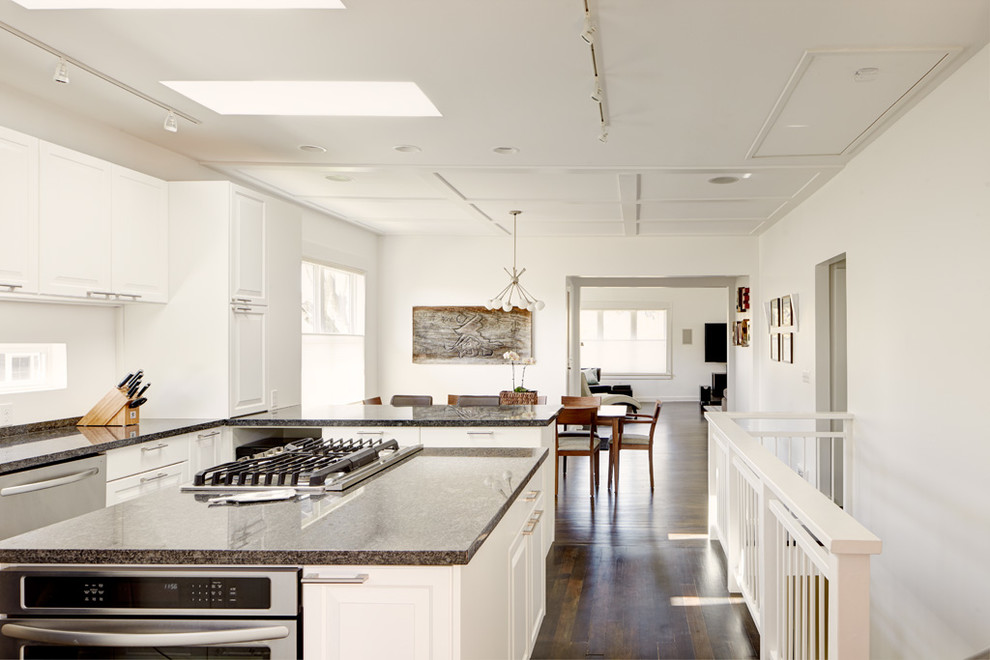 Mittelgroße Moderne Wohnküche in U-Form mit Unterbauwaschbecken, profilierten Schrankfronten, weißen Schränken, Granit-Arbeitsplatte, Küchenrückwand in Schwarz, Küchengeräten aus Edelstahl, dunklem Holzboden und Kücheninsel in Seattle