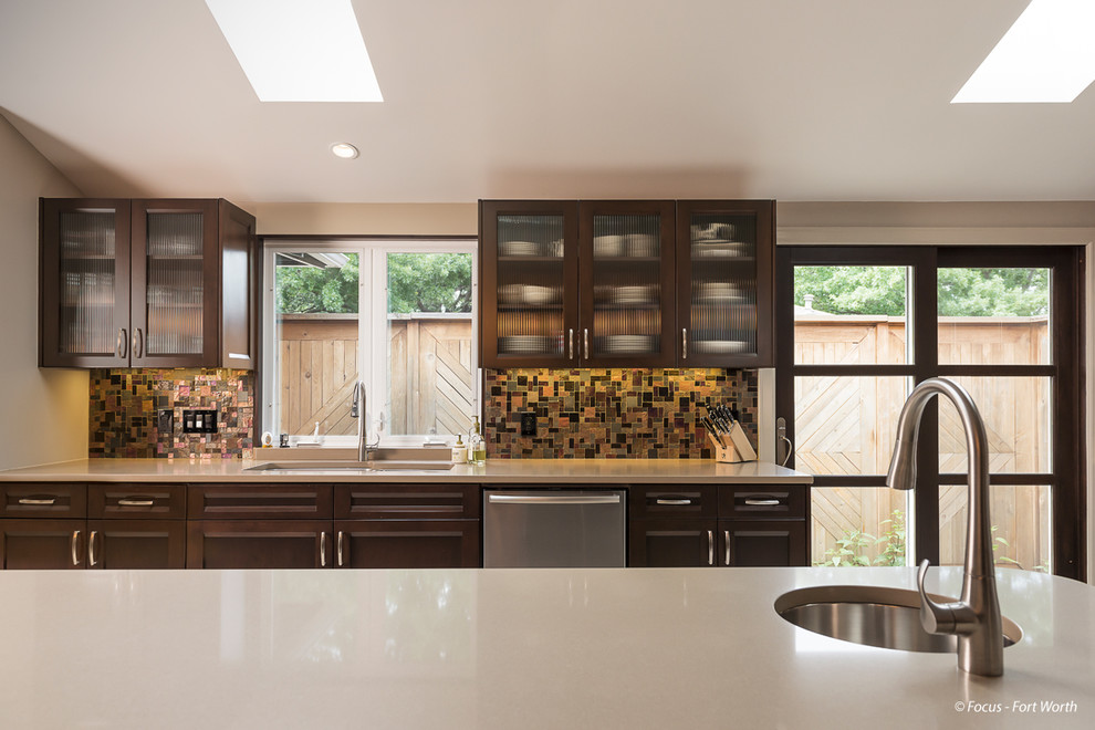Example of a large transitional u-shaped porcelain tile eat-in kitchen design in Dallas with a double-bowl sink, glass-front cabinets, dark wood cabinets, brown backsplash, stainless steel appliances, an island, quartz countertops and glass tile backsplash