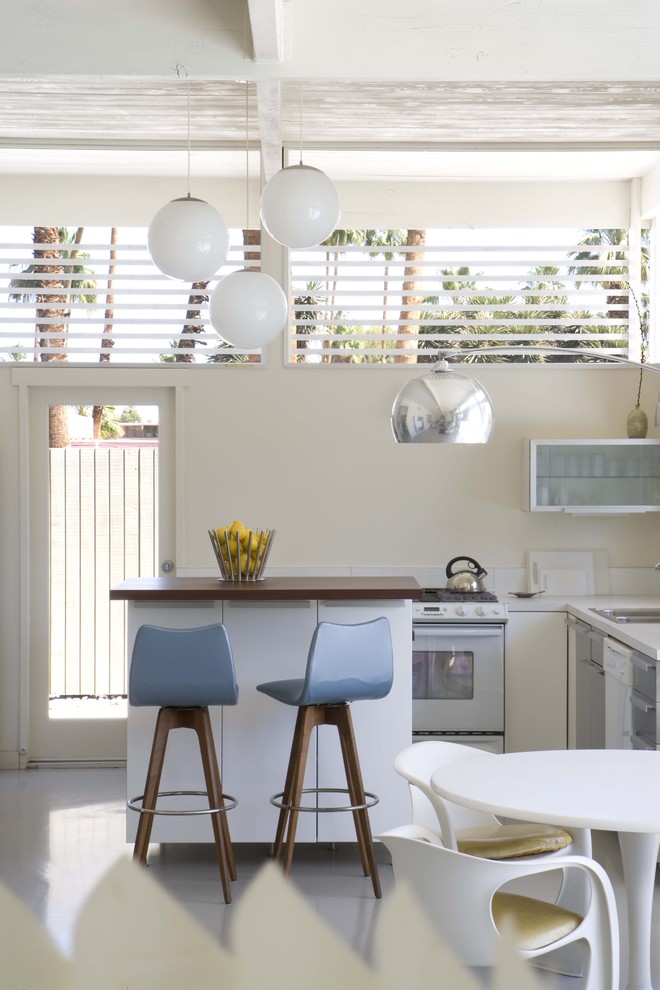 Diseño de cocina retro con puertas de armario blancas, salpicadero blanco y electrodomésticos blancos