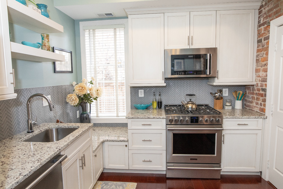 Enclosed kitchen - small farmhouse l-shaped dark wood floor and brown floor enclosed kitchen idea in DC Metro with an undermount sink, shaker cabinets, white cabinets, granite countertops, gray backsplash, glass tile backsplash, stainless steel appliances, no island and beige countertops