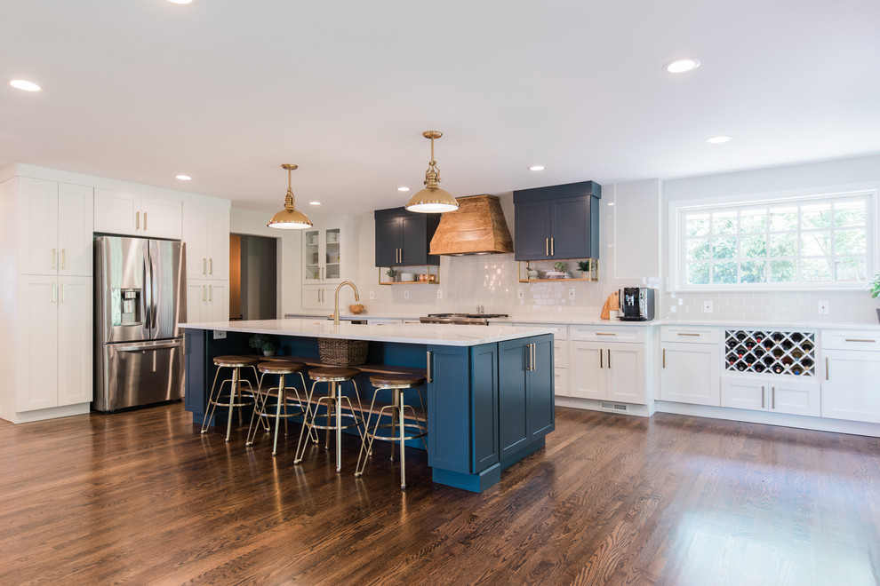 Inspiration for a large transitional l-shaped dark wood floor and brown floor open concept kitchen remodel in DC Metro with a farmhouse sink, shaker cabinets, white cabinets, quartzite countertops, white backsplash, subway tile backsplash, stainless steel appliances, an island and white countertops