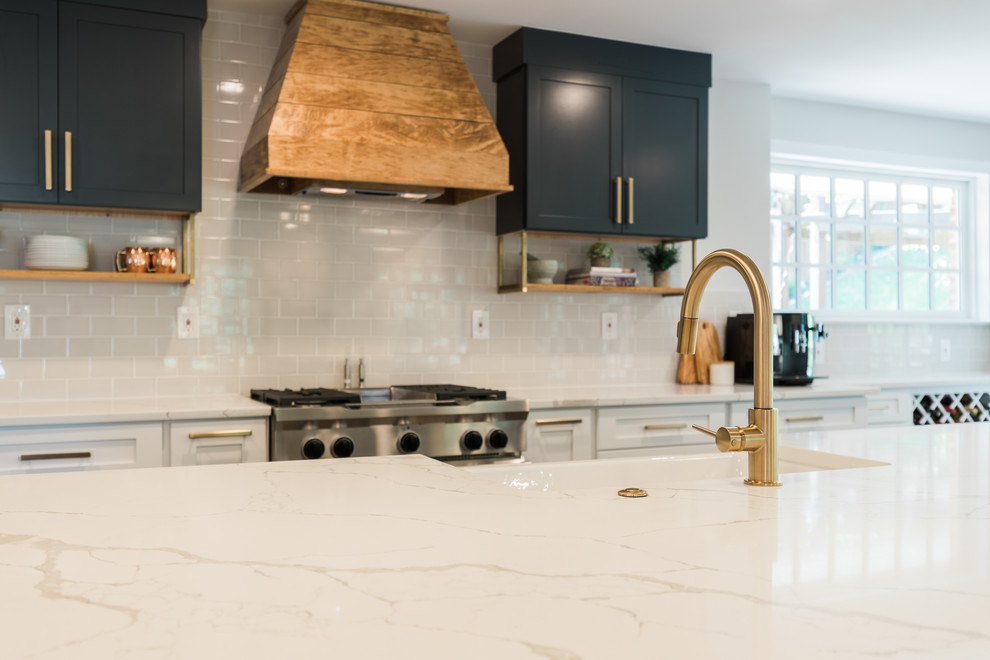 Inspiration for a large transitional l-shaped dark wood floor and brown floor open concept kitchen remodel in DC Metro with a farmhouse sink, shaker cabinets, white cabinets, quartzite countertops, white backsplash, subway tile backsplash, stainless steel appliances, an island and white countertops