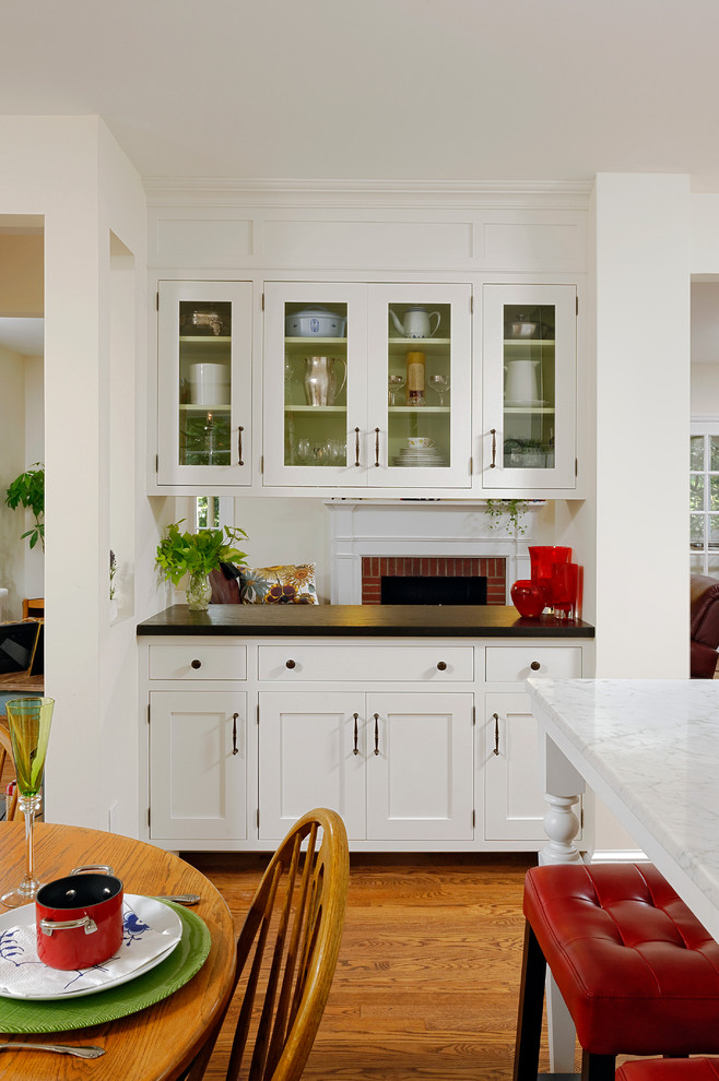 Bild på ett stort vintage kök, med en undermonterad diskho, skåp i shakerstil, vita skåp, vitt stänkskydd, stänkskydd i sten, rostfria vitvaror, mörkt trägolv, en halv köksö och marmorbänkskiva