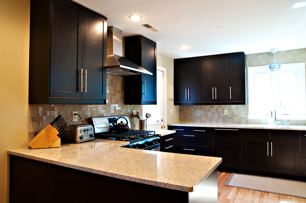 Immagine di una cucina design con lavello sottopiano, ante con riquadro incassato, ante nere, top in granito, paraspruzzi multicolore, paraspruzzi con piastrelle a mosaico e elettrodomestici in acciaio inossidabile