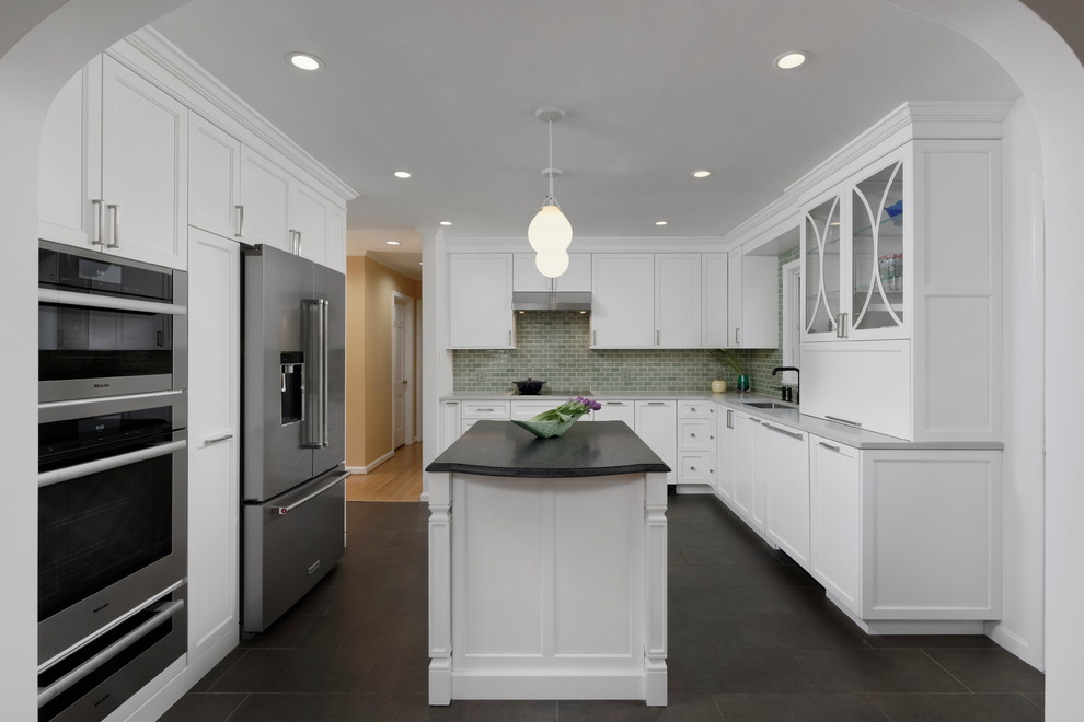 Exempel på ett avskilt, mellanstort klassiskt vit vitt u-kök, med en enkel diskho, släta luckor, vita skåp, bänkskiva i kvarts, grönt stänkskydd, stänkskydd i keramik, rostfria vitvaror, klinkergolv i porslin, en köksö och brunt golv