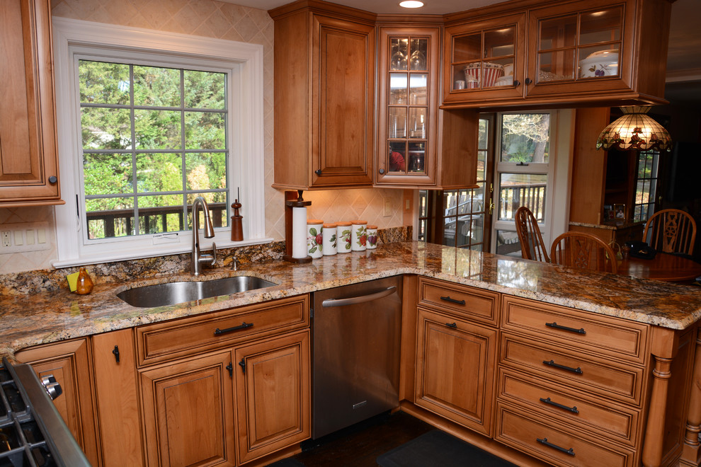 Example of a mid-sized classic l-shaped dark wood floor enclosed kitchen design in DC Metro with an undermount sink, raised-panel cabinets, light wood cabinets, granite countertops, beige backsplash, stainless steel appliances and a peninsula