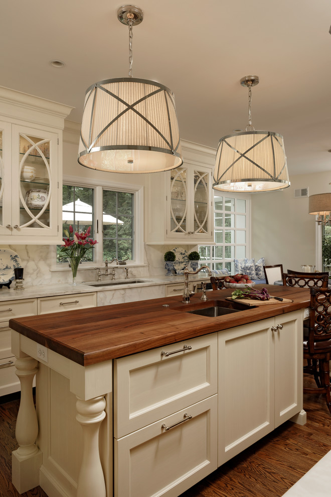 Exempel på ett mellanstort klassiskt kök, med marmorbänkskiva, stänkskydd i sten, mellanmörkt trägolv, en köksö, vita skåp, vitt stänkskydd, rostfria vitvaror, en undermonterad diskho och skåp i shakerstil