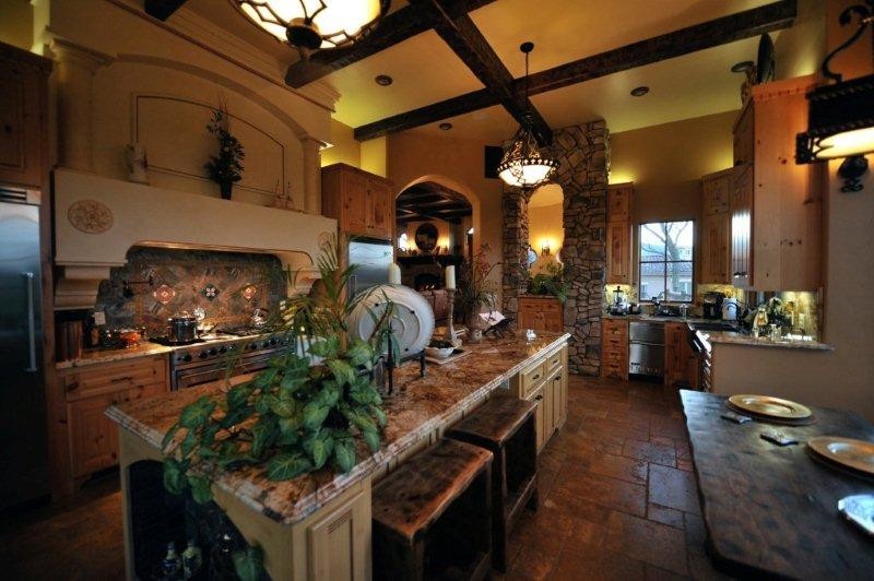 Bild på ett mellanstort medelhavsstil kök, med en rustik diskho, luckor med upphöjd panel, skåp i mellenmörkt trä, granitbänkskiva, brunt stänkskydd, stänkskydd i sten, rostfria vitvaror, klinkergolv i porslin och en köksö