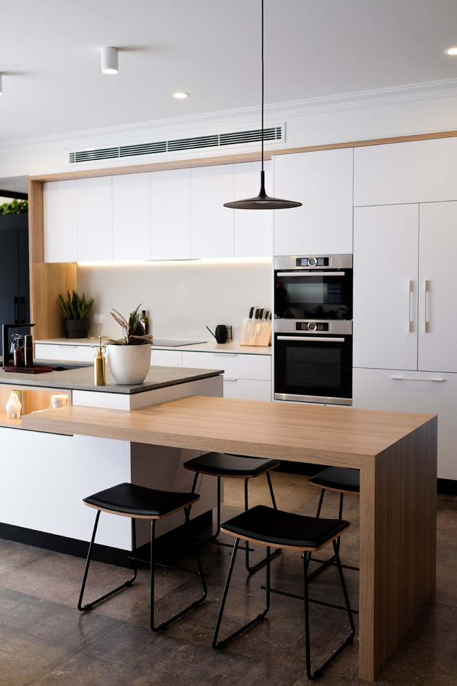 Exempel på ett mellanstort modernt grå grått kök, med en köksö, en undermonterad diskho, vita skåp, bänkskiva i kvarts, vitt stänkskydd, stänkskydd i sten, rostfria vitvaror, klinkergolv i porslin och grått golv