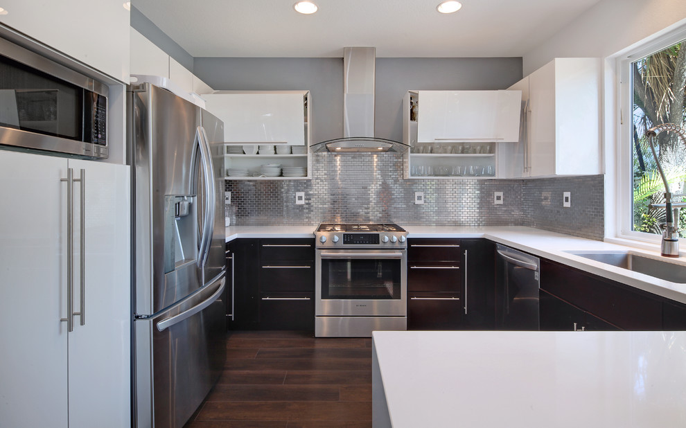 Inspiration for a mid-sized contemporary dark wood floor and beige floor eat-in kitchen remodel in Orange County with a single-bowl sink, flat-panel cabinets, white cabinets, quartz countertops, metallic backsplash, metal backsplash, stainless steel appliances and a peninsula