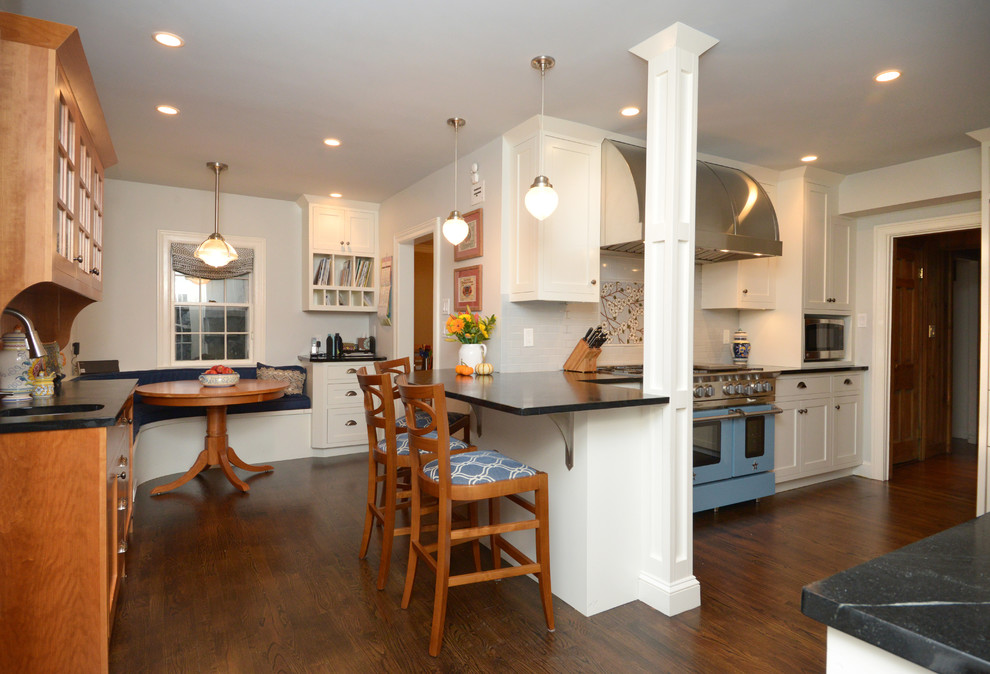 Eat-in kitchen - large traditional dark wood floor eat-in kitchen idea in Boston with a farmhouse sink, shaker cabinets, white cabinets, soapstone countertops, multicolored backsplash, porcelain backsplash, colored appliances and a peninsula