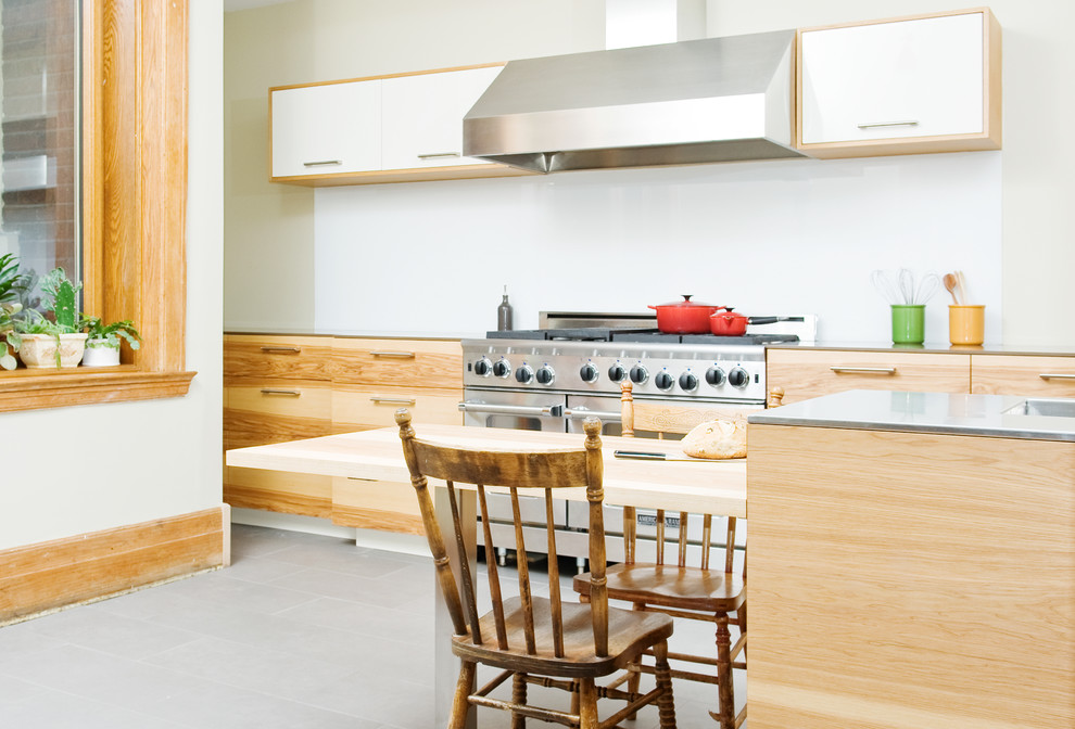 Idéer för ett mellanstort modernt kök, med rostfria vitvaror, en undermonterad diskho, släta luckor, skåp i ljust trä, bänkskiva i kvarts, vitt stänkskydd, betonggolv, en köksö och grått golv