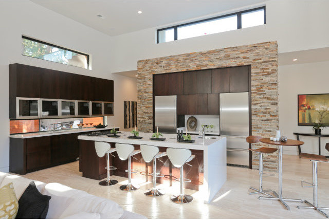 Eat-in kitchen - large modern l-shaped travertine floor eat-in kitchen idea in Phoenix with flat-panel cabinets, dark wood cabinets, laminate countertops, stainless steel appliances and an island