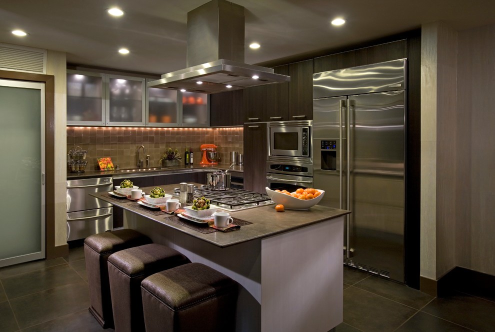 Пример оригинального дизайна: угловая кухня в современном стиле с врезной мойкой, плоскими фасадами, темными деревянными фасадами, коричневым фартуком и техникой из нержавеющей стали