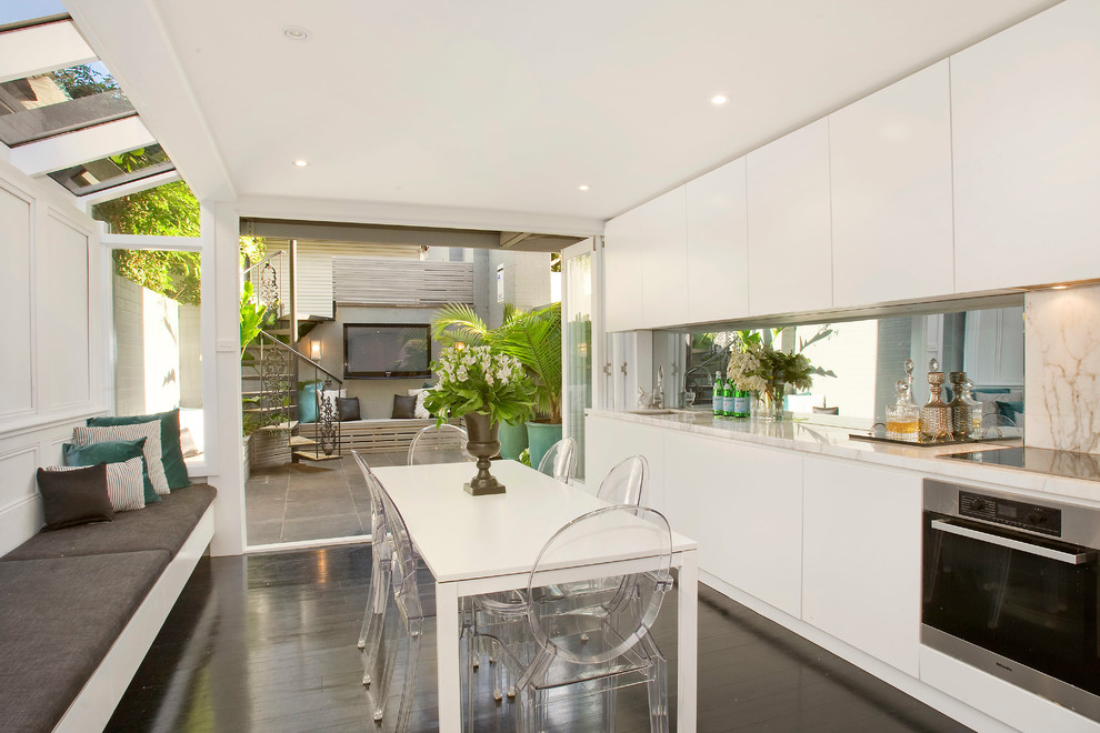 Photo of a contemporary single-wall kitchen in Sydney with a submerged sink, flat-panel cabinets and white cabinets.