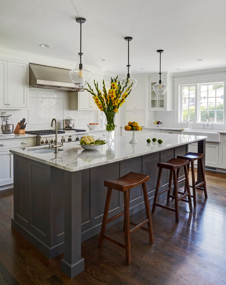 Inspiration for a large transitional dark wood floor kitchen remodel in Chicago with a single-bowl sink, recessed-panel cabinets, white cabinets, marble countertops, white backsplash, subway tile backsplash, stainless steel appliances and an island
