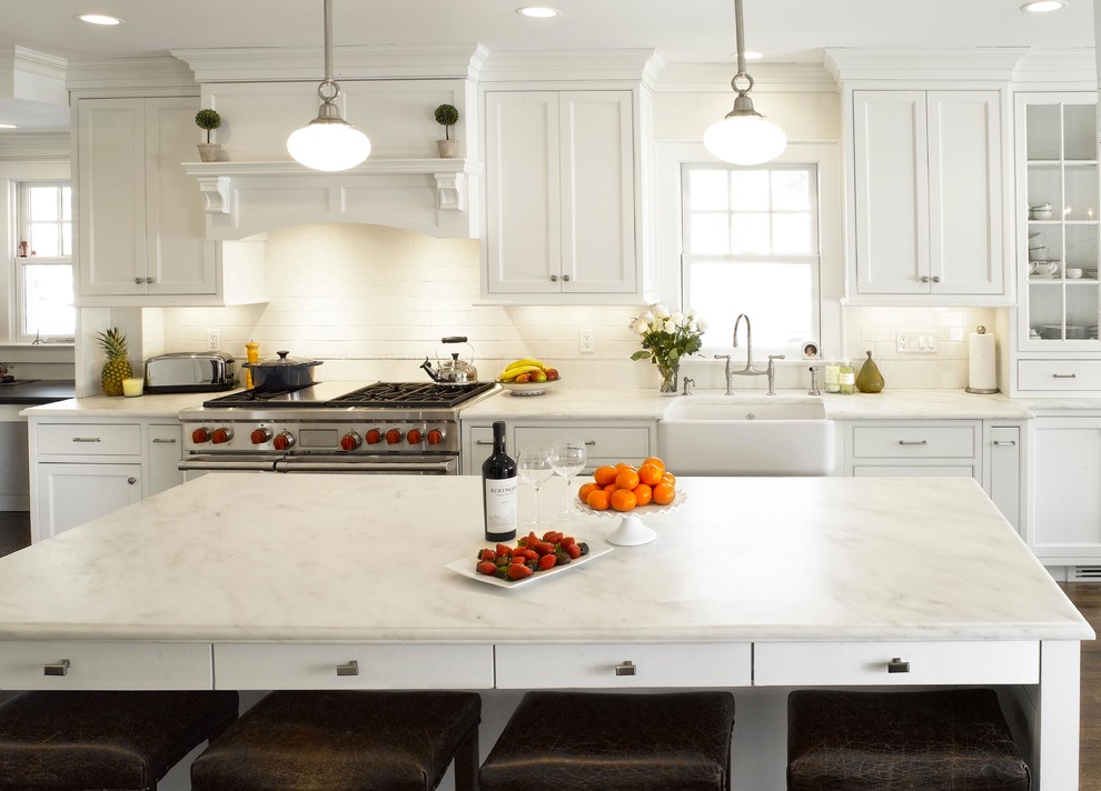 Eat-in kitchen - traditional dark wood floor eat-in kitchen idea in New York with a farmhouse sink, white cabinets, marble countertops, white backsplash, subway tile backsplash and an island
