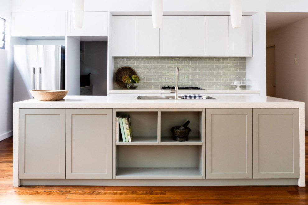 Photo of a medium sized traditional galley kitchen pantry in Sydney with a built-in sink, shaker cabinets, white cabinets, concrete worktops, grey splashback, ceramic splashback, stainless steel appliances, medium hardwood flooring, an island, brown floors and beige worktops.