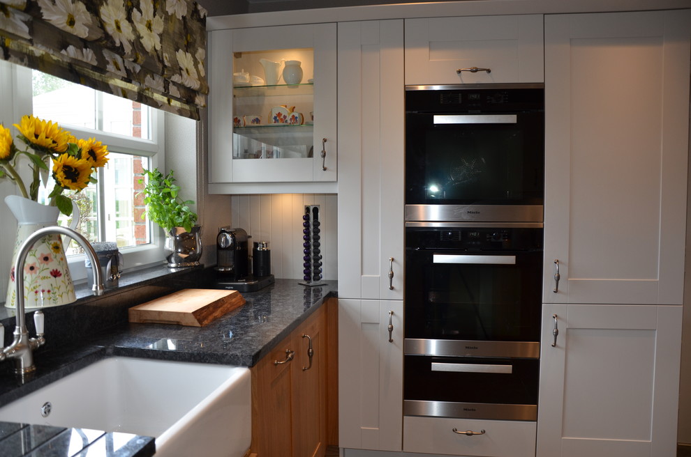Medium sized classic galley kitchen/diner in Other with shaker cabinets, granite worktops, an island, a double-bowl sink, white cabinets, white splashback, brick splashback, white appliances, ceramic flooring and grey floors.
