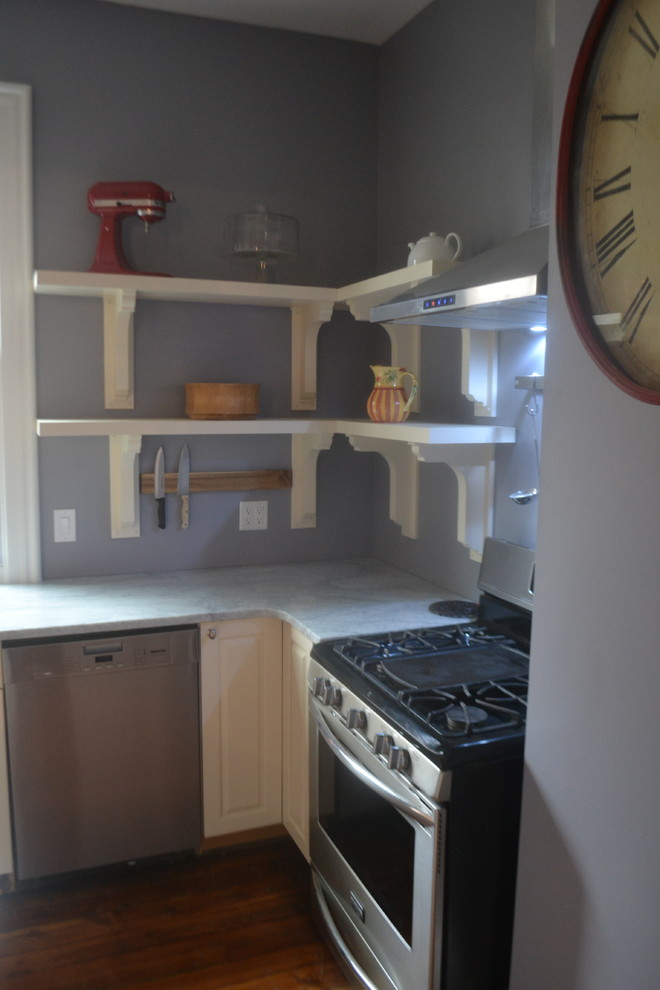 ナッシュビルにある高級な小さなヴィクトリアン調のおしゃれなアイランドキッチン (レイズドパネル扉のキャビネット、白いキャビネット、大理石カウンター、シルバーの調理設備、無垢フローリング) の写真