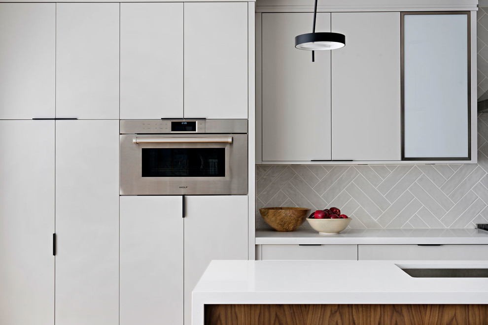 Inspiration for a mid-sized modern l-shaped light wood floor open concept kitchen remodel in Toronto with an undermount sink, flat-panel cabinets, gray cabinets, quartz countertops, gray backsplash, ceramic backsplash, stainless steel appliances, an island and white countertops