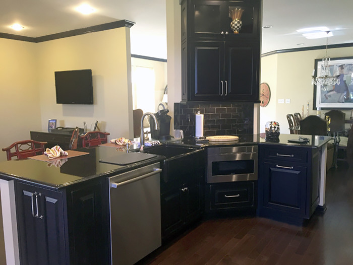 Bild på ett mellanstort vintage kök, med en rustik diskho, luckor med upphöjd panel, svarta skåp, bänkskiva i onyx, svart stänkskydd, stänkskydd i tunnelbanekakel, rostfria vitvaror, mörkt trägolv och en köksö