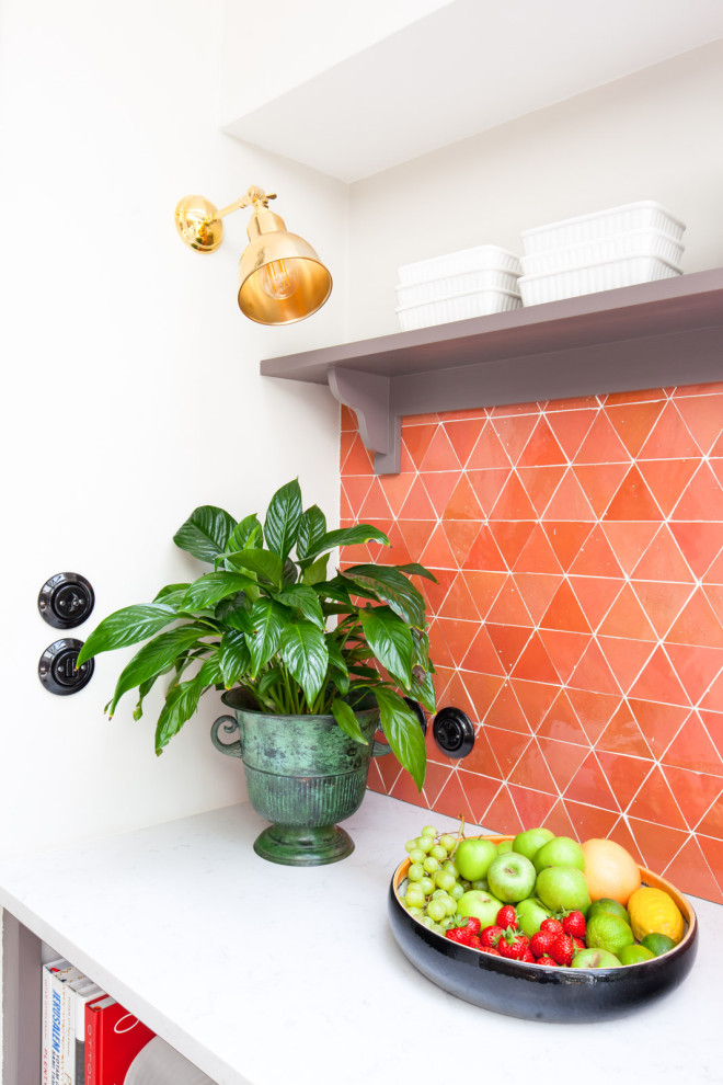 Aménagement d'une cuisine moderne en U fermée et de taille moyenne avec un placard à porte plane, des portes de placard violettes, une crédence orange, une crédence en carreau de porcelaine et un sol gris.