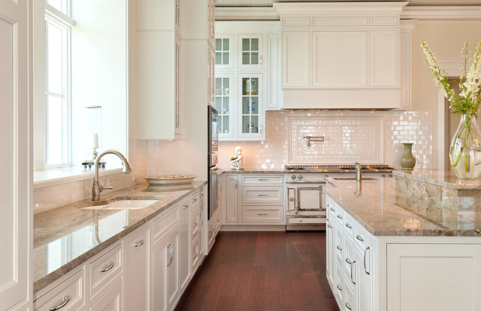 Inspiration for a mid-sized timeless l-shaped dark wood floor and brown floor eat-in kitchen remodel in Tampa with a double-bowl sink, shaker cabinets, white cabinets, granite countertops, white backsplash, subway tile backsplash, white appliances and an island