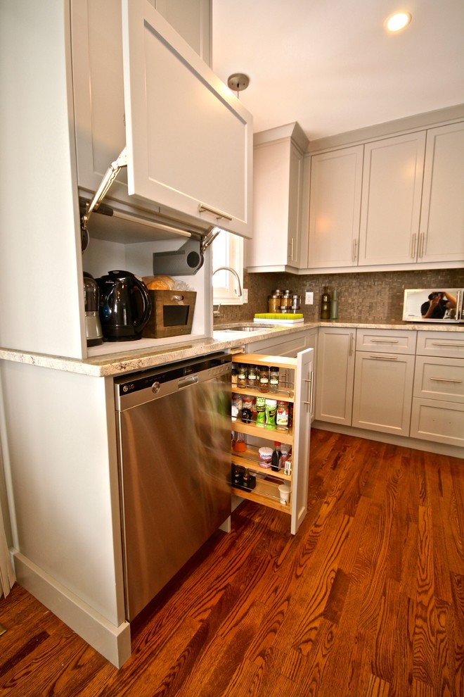 Photo of a small traditional l-shaped kitchen/diner in Toronto with a double-bowl sink, shaker cabinets, dark wood cabinets, granite worktops, beige splashback, ceramic splashback, stainless steel appliances, medium hardwood flooring and an island.