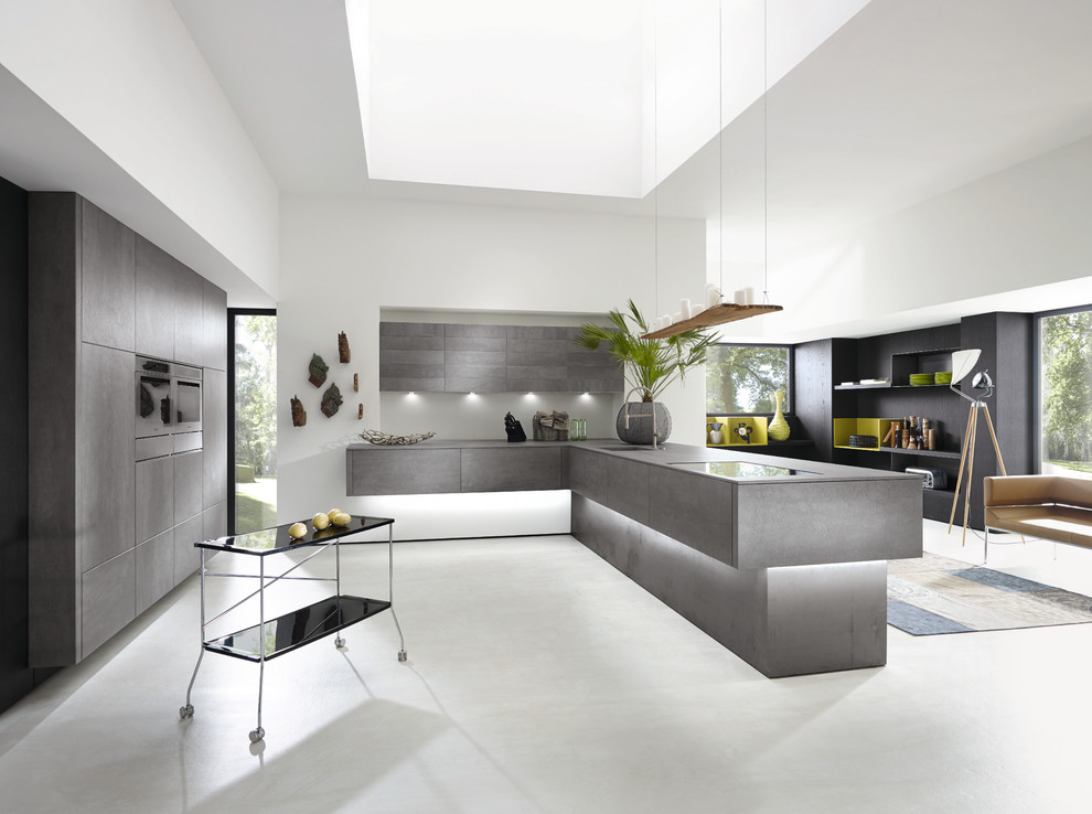 Inspiration for a medium sized modern kitchen in New York with a submerged sink, grey cabinets, concrete worktops, white splashback, cement tile splashback, concrete flooring, an island and stainless steel appliances.