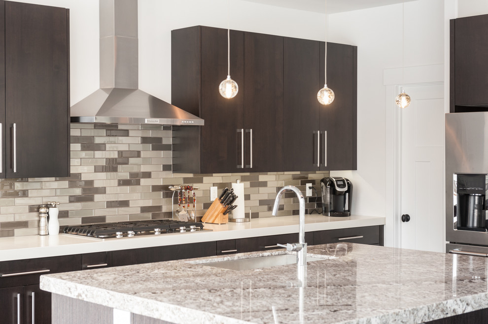 Inspiration for a mid-sized modern l-shaped medium tone wood floor and brown floor eat-in kitchen remodel in Salt Lake City with flat-panel cabinets, dark wood cabinets, an island, an undermount sink, granite countertops, beige backsplash, subway tile backsplash and stainless steel appliances