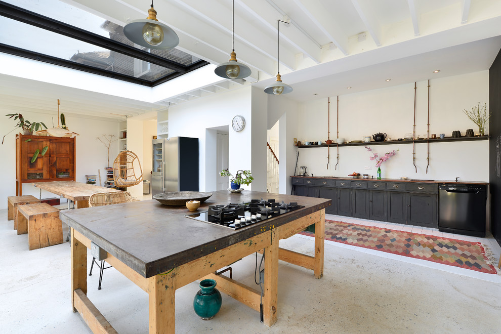 Foto på ett mellanstort eklektiskt linjärt kök med öppen planlösning, med luckor med infälld panel, svarta skåp, bänkskiva i betong, svarta vitvaror, betonggolv, en köksö och grått golv
