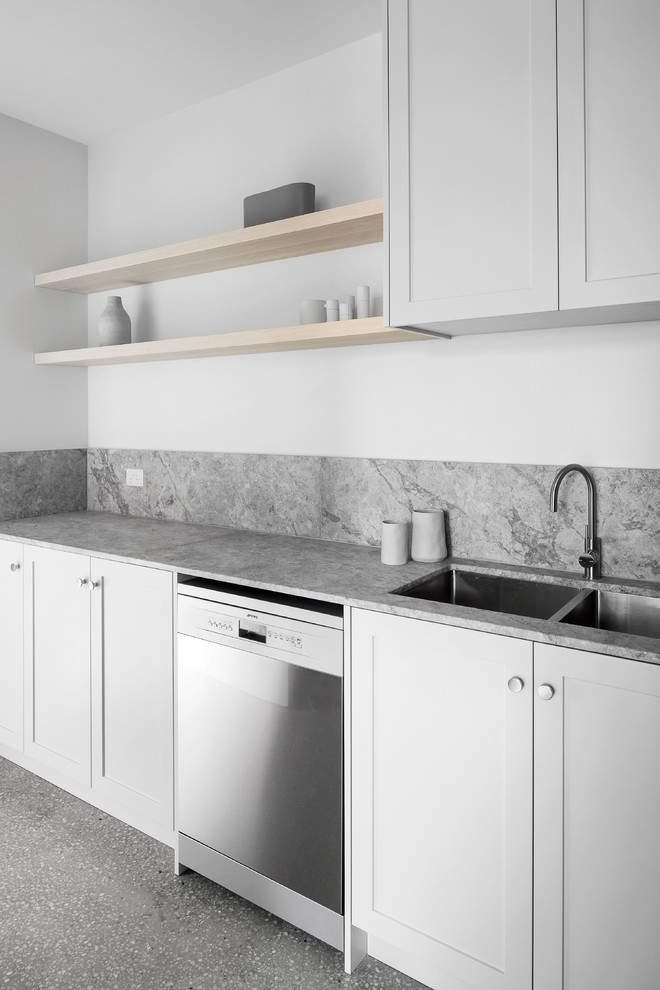 Foto di una grande cucina design con ante in stile shaker, paraspruzzi grigio, pavimento in cemento e top grigio