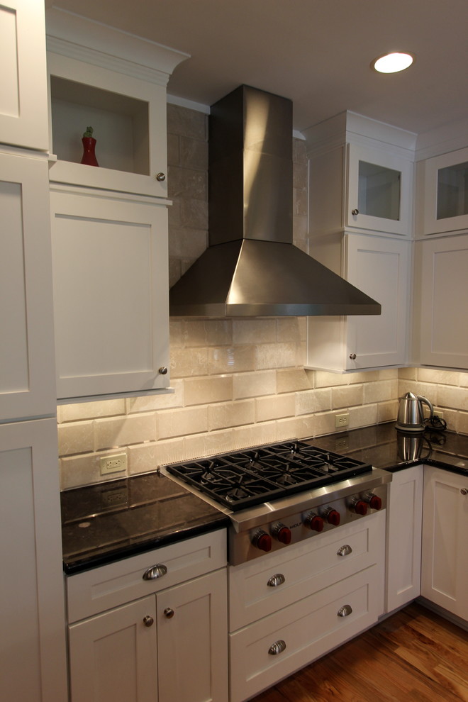 Idéer för att renovera ett mellanstort funkis kök, med en enkel diskho, skåp i shakerstil, vita skåp, granitbänkskiva, beige stänkskydd, stänkskydd i tunnelbanekakel, rostfria vitvaror, mellanmörkt trägolv och en köksö