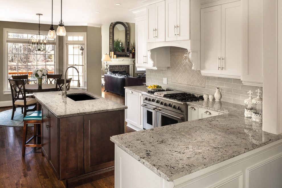 Inspiration for a timeless l-shaped dark wood floor and brown floor kitchen remodel in Atlanta with an undermount sink, shaker cabinets, white cabinets, gray backsplash, stainless steel appliances and an island