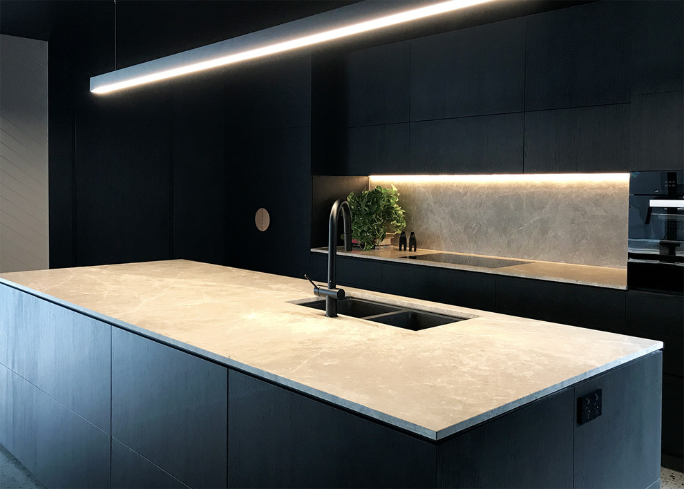 Example of a large minimalist single-wall concrete floor and gray floor kitchen pantry design in Melbourne with an undermount sink, flat-panel cabinets, dark wood cabinets, marble countertops, gray backsplash, marble backsplash, black appliances and an island