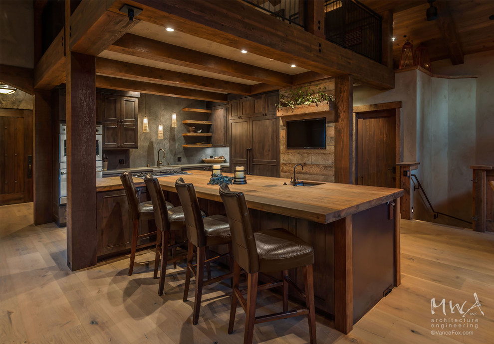 Foto på ett mycket stort rustikt kök, med en rustik diskho, luckor med infälld panel, träbänkskiva, grått stänkskydd, rostfria vitvaror, ljust trägolv, en köksö och skåp i mörkt trä