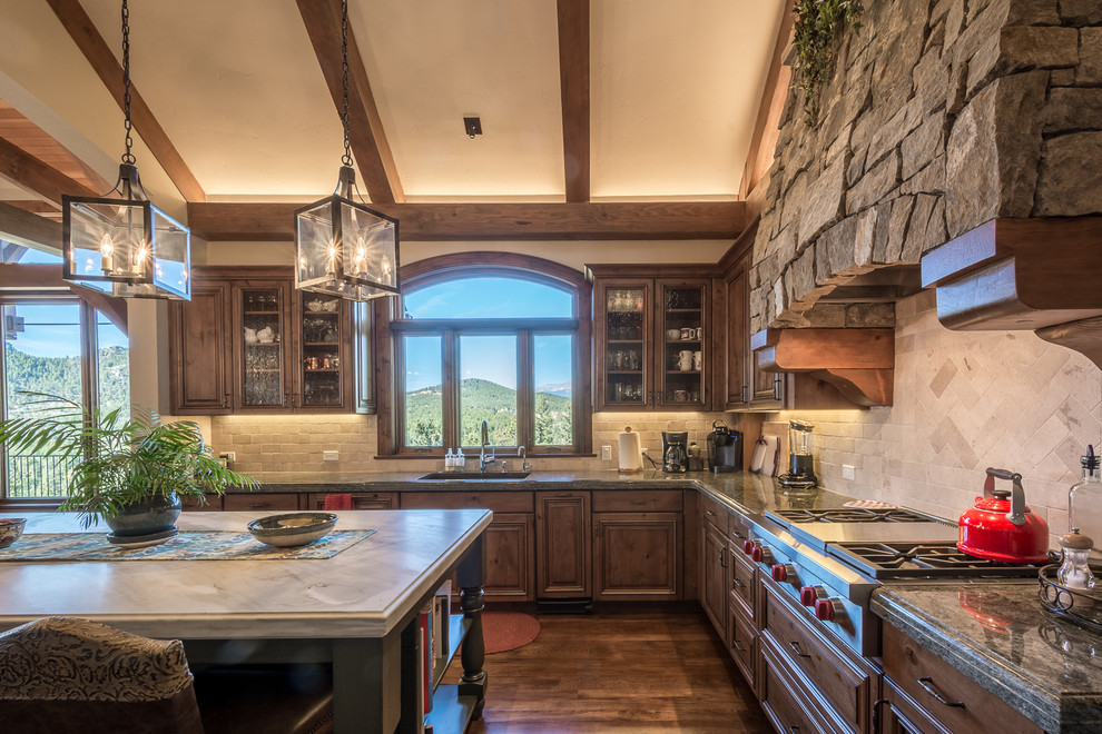 Design ideas for a rustic l-shaped kitchen in Denver with a single-bowl sink, glass-front cabinets, dark wood cabinets, beige splashback, stainless steel appliances, dark hardwood flooring, an island and brown floors.