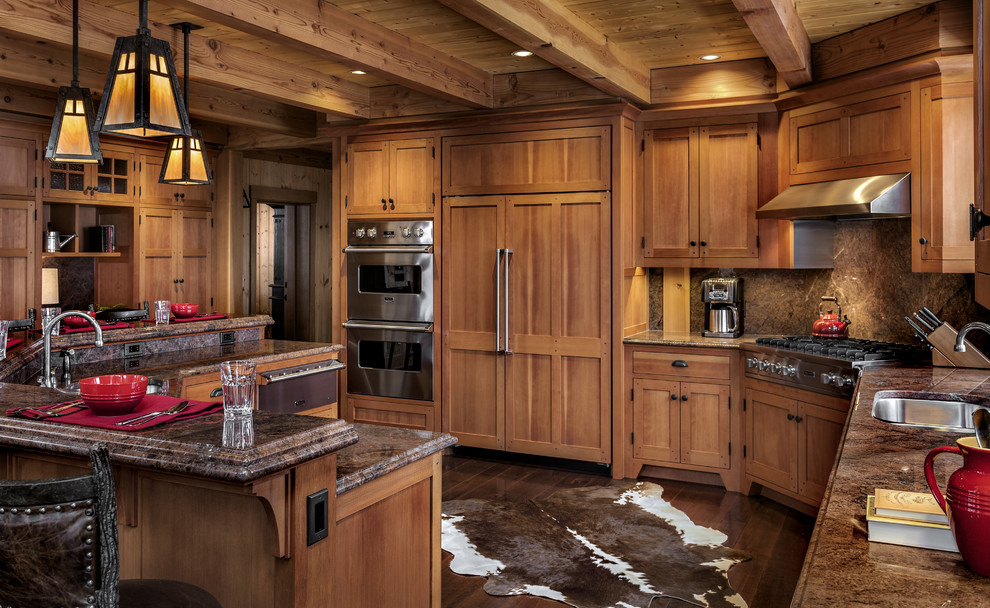 Rustik inredning av ett kök, med en undermonterad diskho, skåp i shakerstil, skåp i mellenmörkt trä, brunt stänkskydd, rostfria vitvaror, mörkt trägolv och granitbänkskiva
