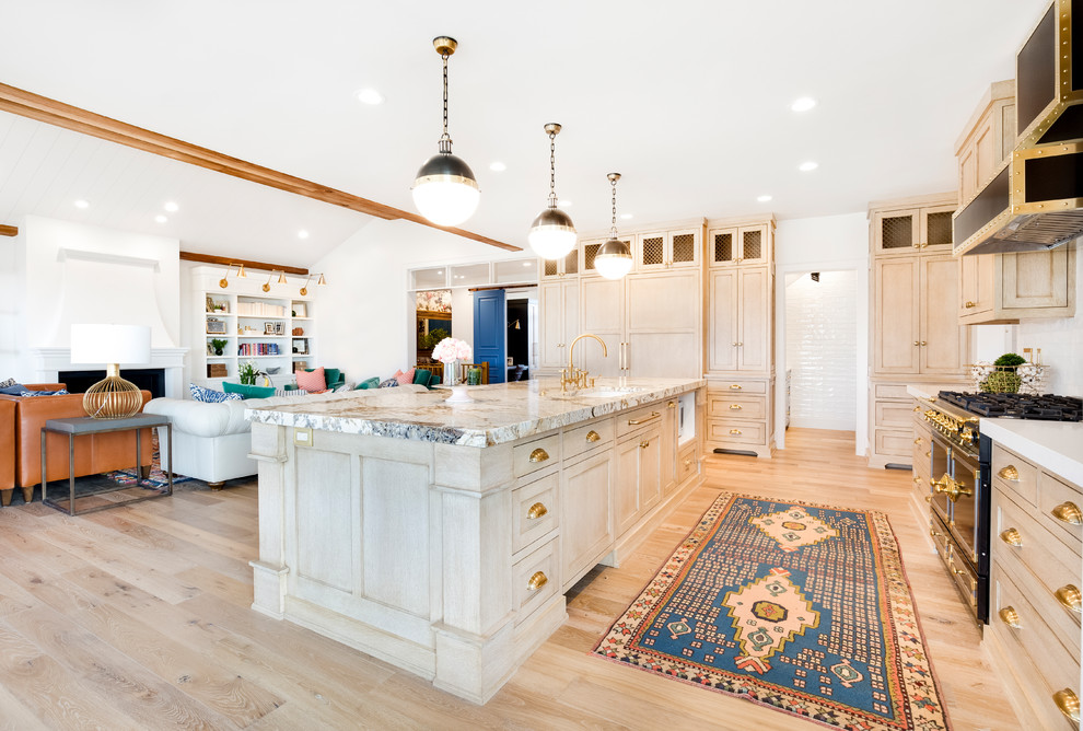 Inspiration for a large eclectic open concept kitchen remodel in Salt Lake City with a drop-in sink, light wood cabinets, marble countertops, white backsplash, black appliances and an island