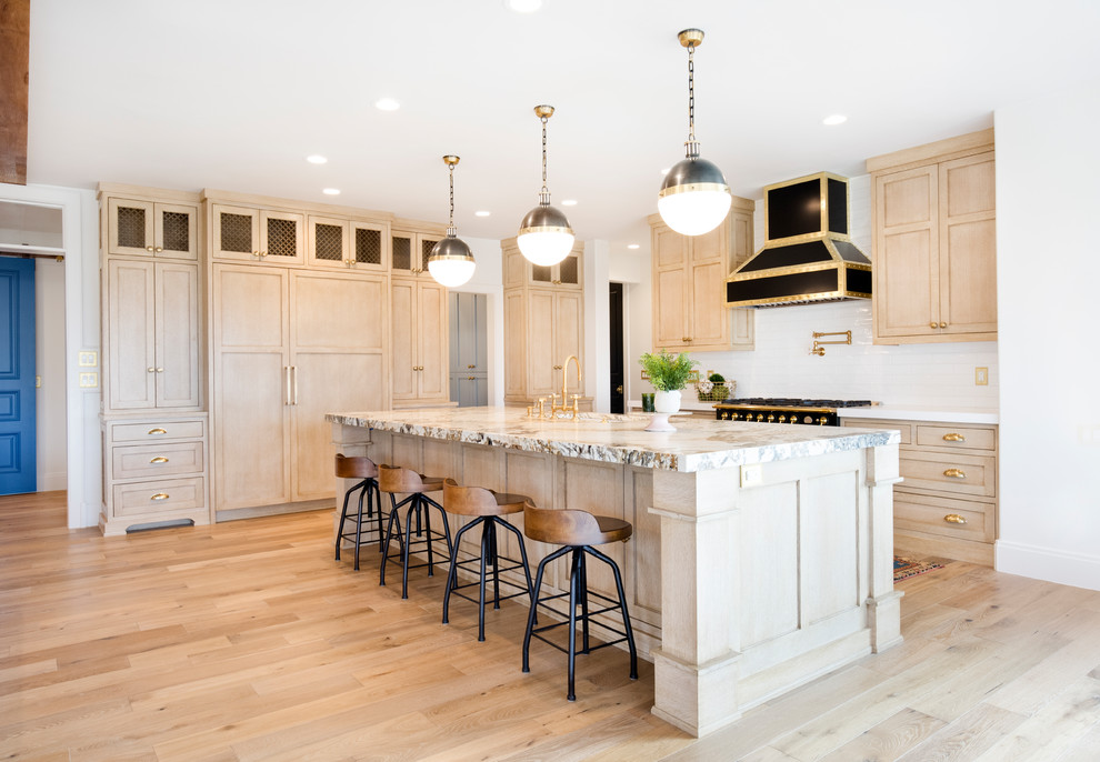 Exemple d'une grande cuisine ouverte chic en bois clair et L avec plan de travail en marbre, une crédence blanche, un électroménager noir, îlot, un placard à porte shaker, parquet clair et un sol beige.