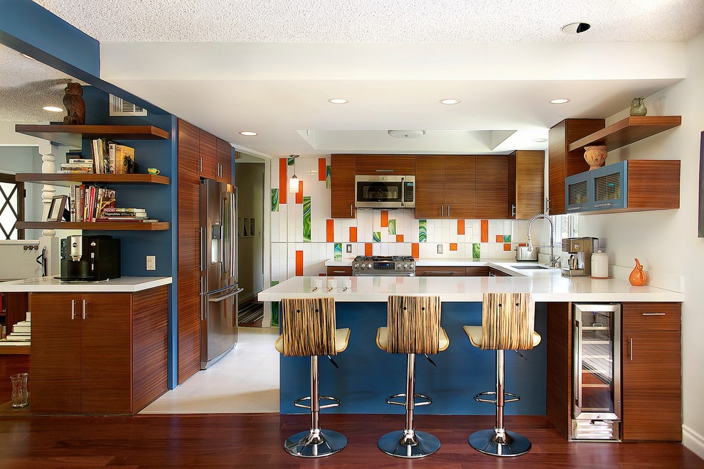 ロサンゼルスにあるミッドセンチュリースタイルのおしゃれなキッチン (フラットパネル扉のキャビネット、中間色木目調キャビネット、マルチカラーのキッチンパネル、シルバーの調理設備) の写真