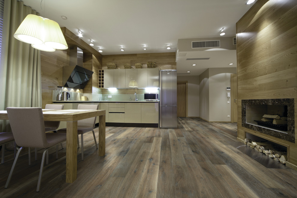 Mid-sized trendy galley medium tone wood floor and beige floor enclosed kitchen photo in Denver with an integrated sink, raised-panel cabinets, medium tone wood cabinets, granite countertops, beige backsplash, subway tile backsplash, stainless steel appliances and an island