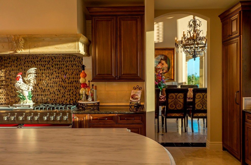 Mediterrane Wohnküche mit profilierten Schrankfronten, hellbraunen Holzschränken, Granit-Arbeitsplatte, bunter Rückwand, Rückwand aus Glasfliesen, Küchengeräten aus Edelstahl und Kücheninsel in Phoenix