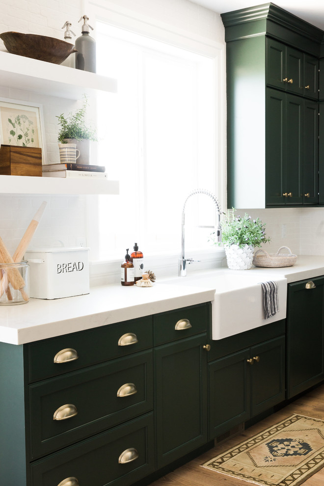 Inspiration for a large timeless l-shaped medium tone wood floor and brown floor eat-in kitchen remodel in Salt Lake City with an integrated sink, recessed-panel cabinets, green cabinets, white backsplash and an island