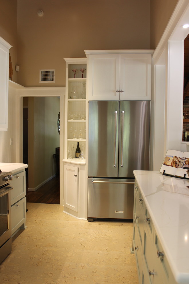 Inredning av ett retro mellanstort vit vitt kök, med en undermonterad diskho, skåp i shakerstil, gröna skåp, bänkskiva i kvarts, vitt stänkskydd, stänkskydd i keramik, rostfria vitvaror, korkgolv och beiget golv