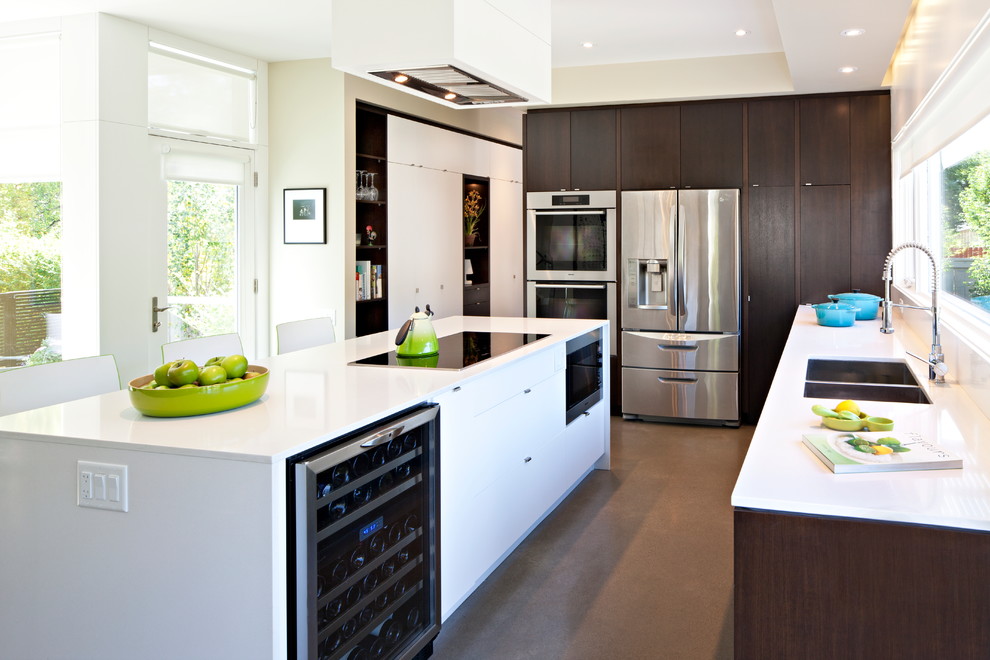 Photo of a medium sized contemporary l-shaped enclosed kitchen in Calgary with a double-bowl sink, flat-panel cabinets, dark wood cabinets, engineered stone countertops, window splashback, stainless steel appliances, concrete flooring, an island and grey floors.