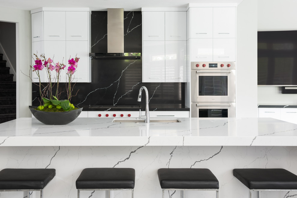 Esempio di una cucina contemporanea di medie dimensioni con lavello a doppia vasca, ante lisce, elettrodomestici in acciaio inossidabile, paraspruzzi nero e top grigio