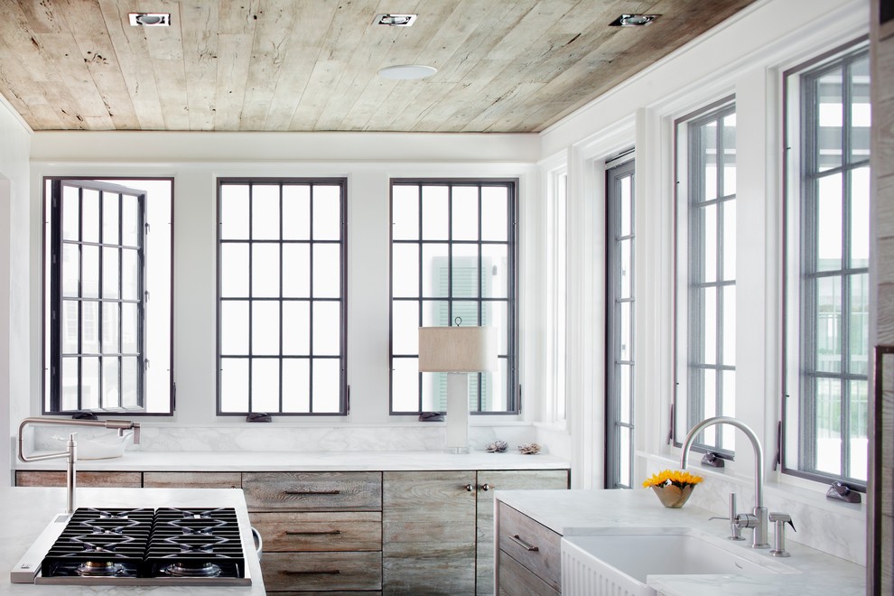 Ejemplo de cocina costera con fregadero sobremueble, armarios con paneles lisos, puertas de armario de madera oscura y salpicadero blanco